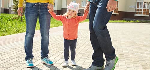 Co-Guardianship toddler holding hands with two adults