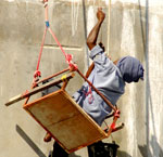 painter on teetering scaffolding